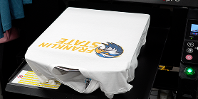 A decorated white t-shirt on a direct-to-garment printer